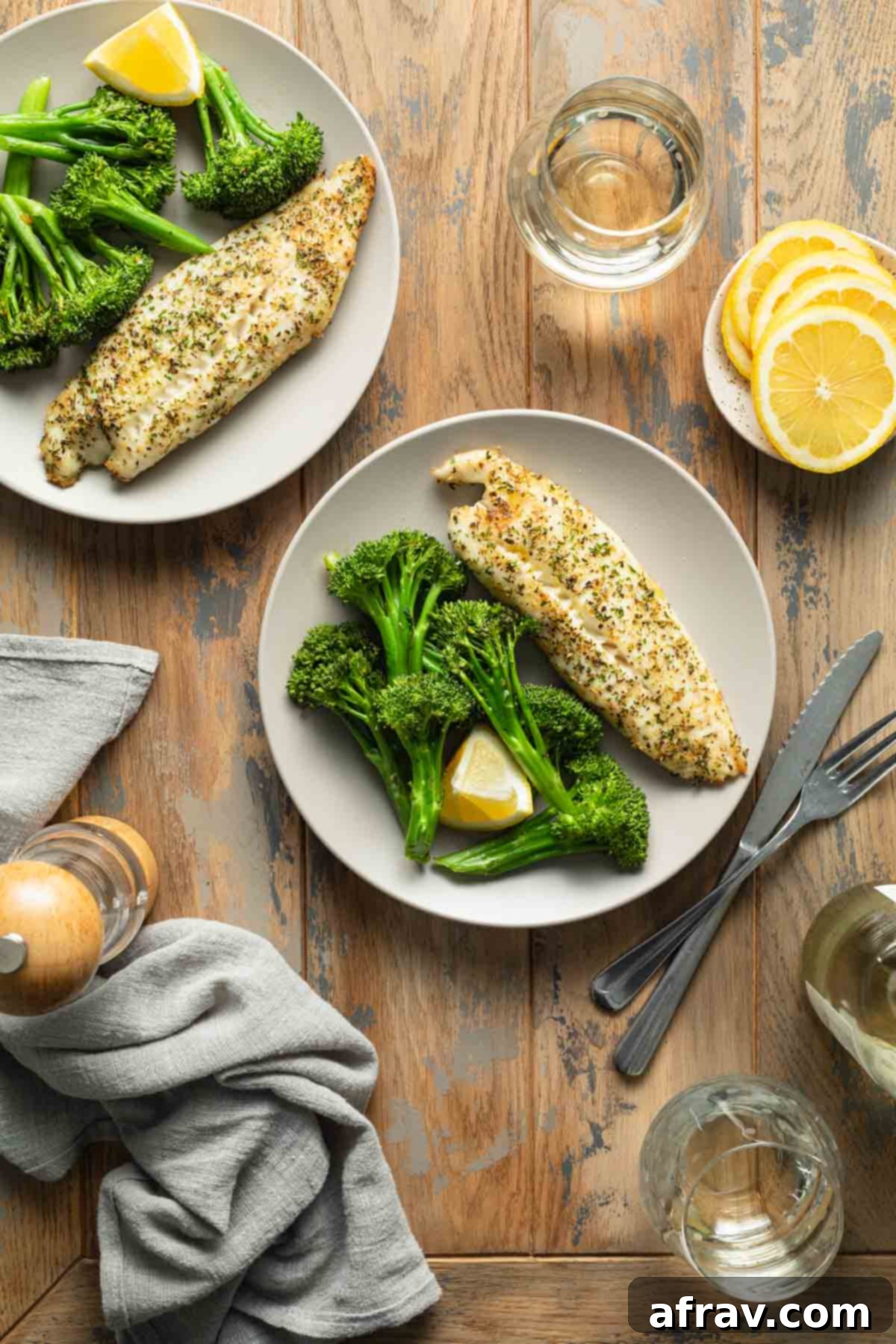 Overhead view of two aesthetically pleasing plates of air fryer tilapia served with roasted broccoli, perfect for a healthy meal.