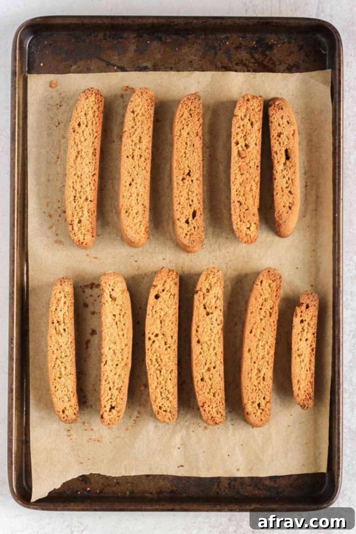 Sliced biscotti on a parchment paper lined baking sheet after baking the second time.