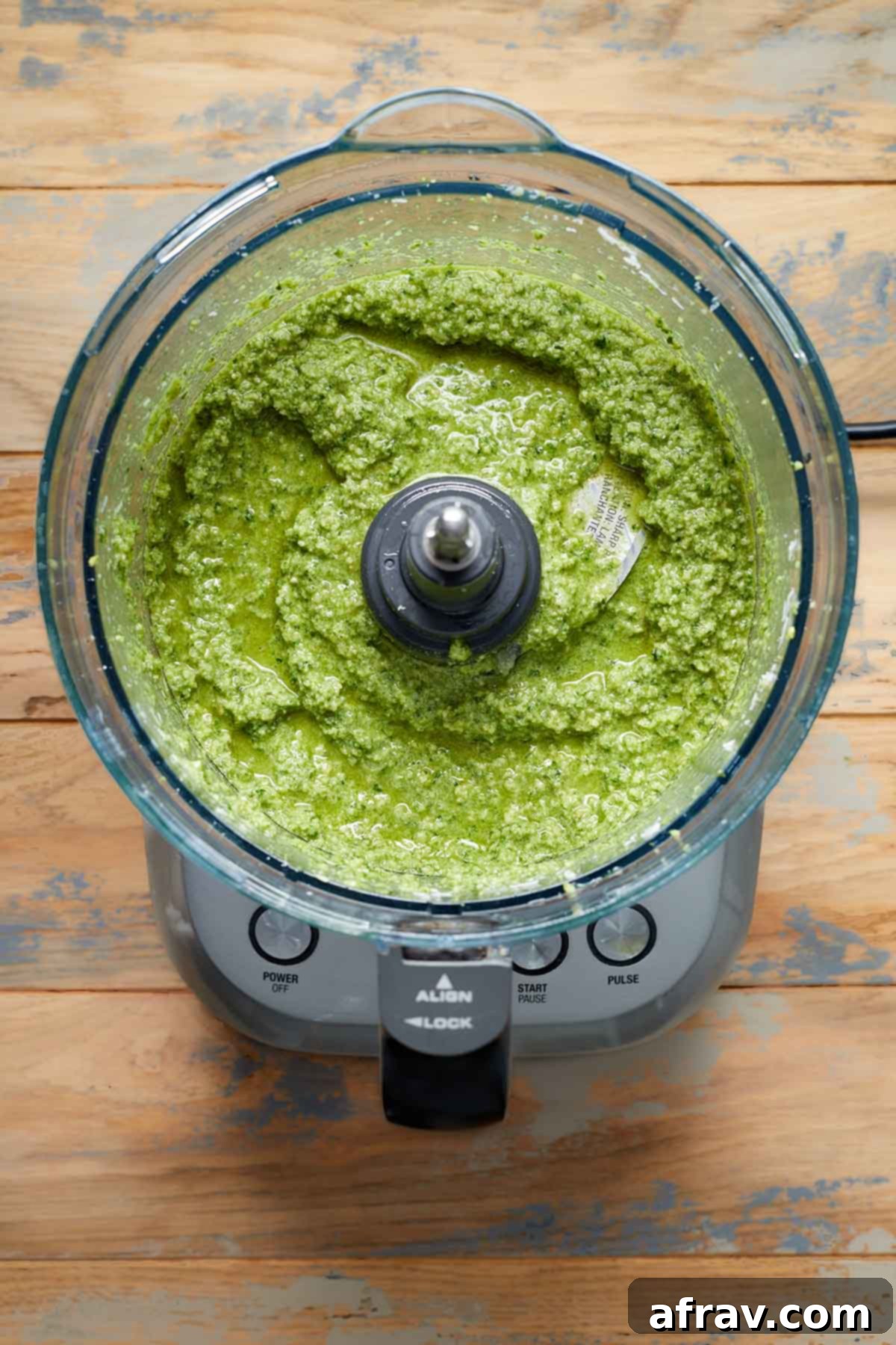 Fully blended pumpkin seed pesto in a food processor, ready to be transferred.