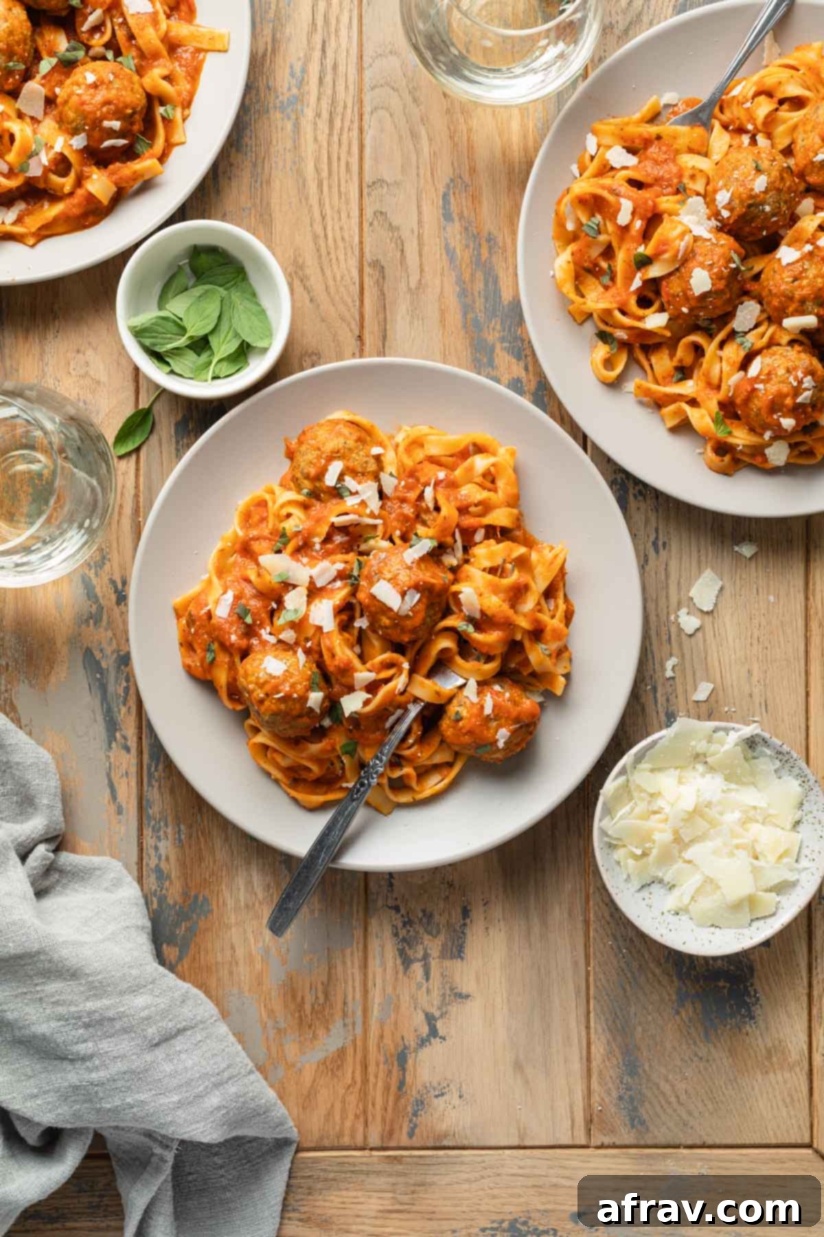 Overhead view of plates of pasta and turkey meatballs.