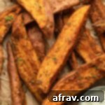 Close up view of air fryer sweet potato wedges arranged on brown parchment paper.