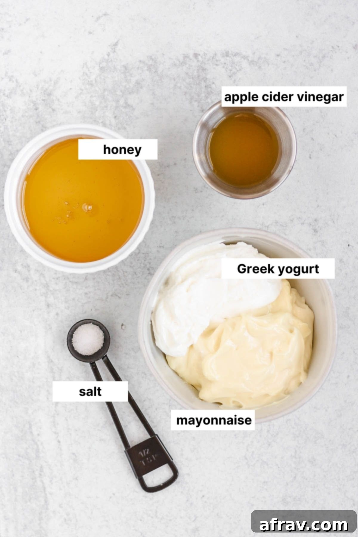 Labeled ingredients for the creamy broccoli salad dressing: mayonnaise, Greek yogurt, apple cider vinegar, honey, and sea salt.