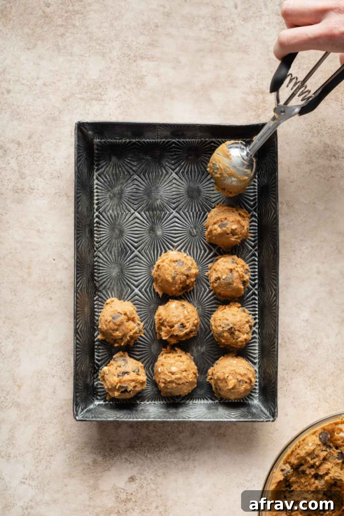 Irresistible Air Fryer Chocolate Chip Cookies 5 Cookie dough balls being scooped onto a parchment-lined tray, ready for chilling.