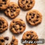 Irresistible Air Fryer Chocolate Chip Cookies 10 Overhead view of air fryer chocolate chip cookies arranged on a beige surface, ready to be enjoyed.