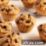 Air fryer muffins with chocolate chips arranged on a pink surface.
