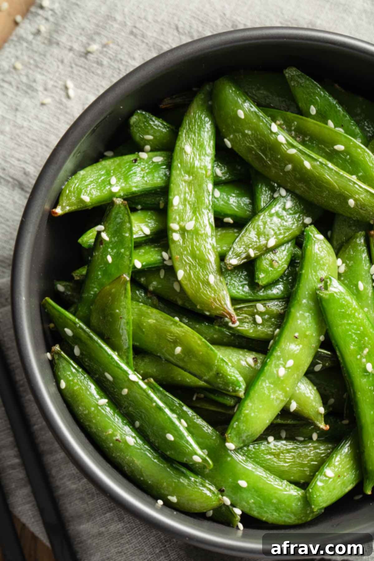 Crispy Air Fryer Snap Peas 2 Close up view of perfectly air-fried roasted sugar snap peas, showing their tender-crisp texture and vibrant green color, ready to be served as a healthy side dish.