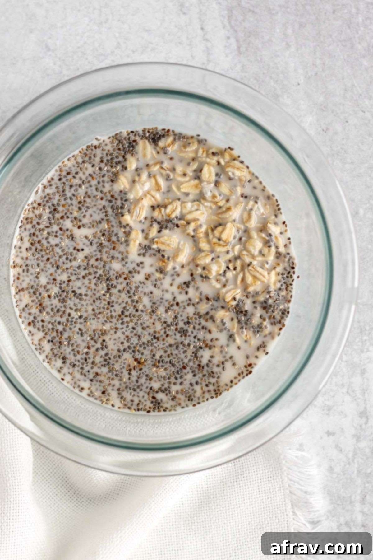 Mixing bowl with oats, milk, and chia seeds.