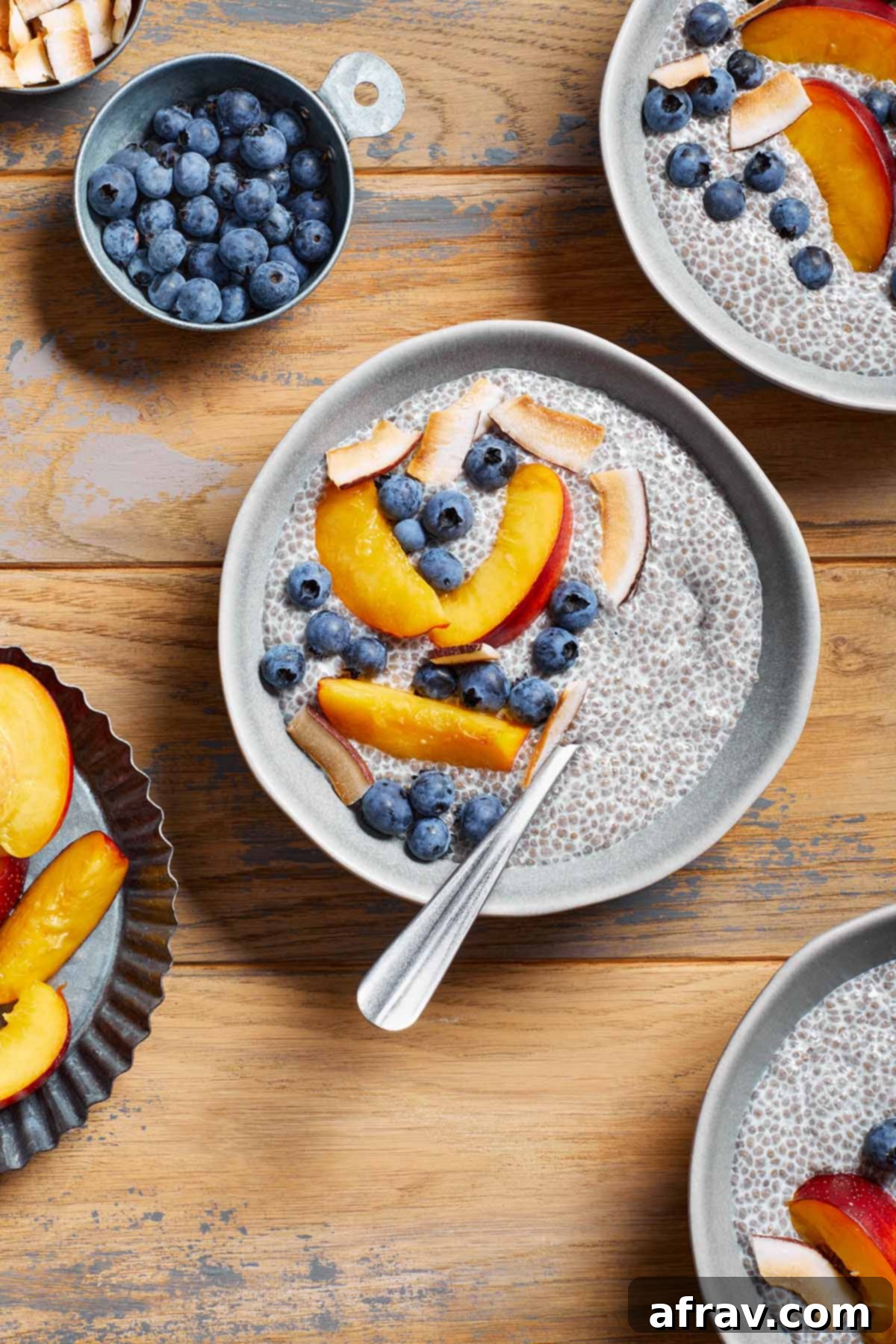 An inviting overhead view of multiple bowls of creamy oat milk chia pudding, each artfully topped with a colorful assortment of fresh fruit, highlighting the versatility of toppings.