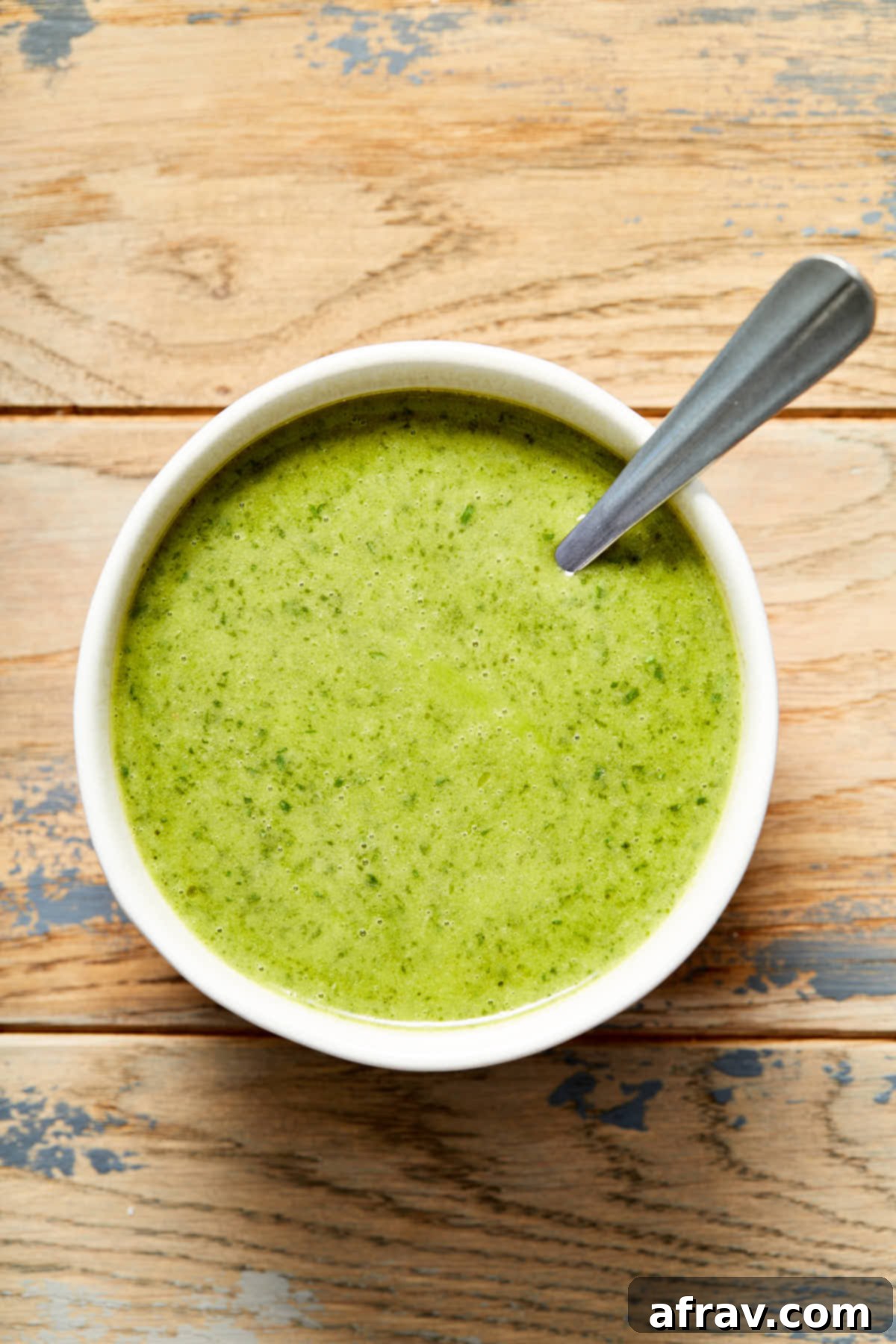 Jalapeño lime vinaigrette in a bowl with a spoon inserted into it.