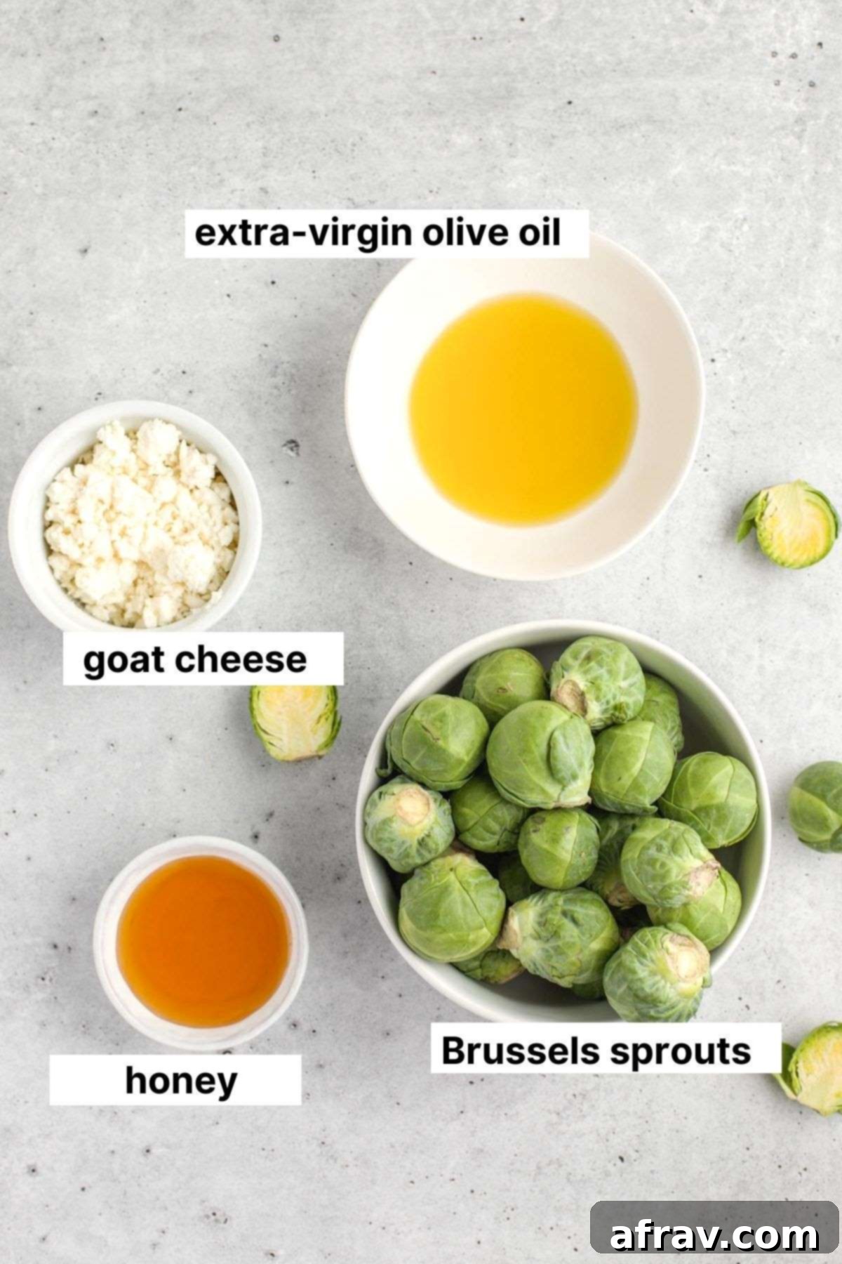 Labeled ingredients for Brussels sprouts with goat cheese and honey, neatly arranged on a rustic wooden board.