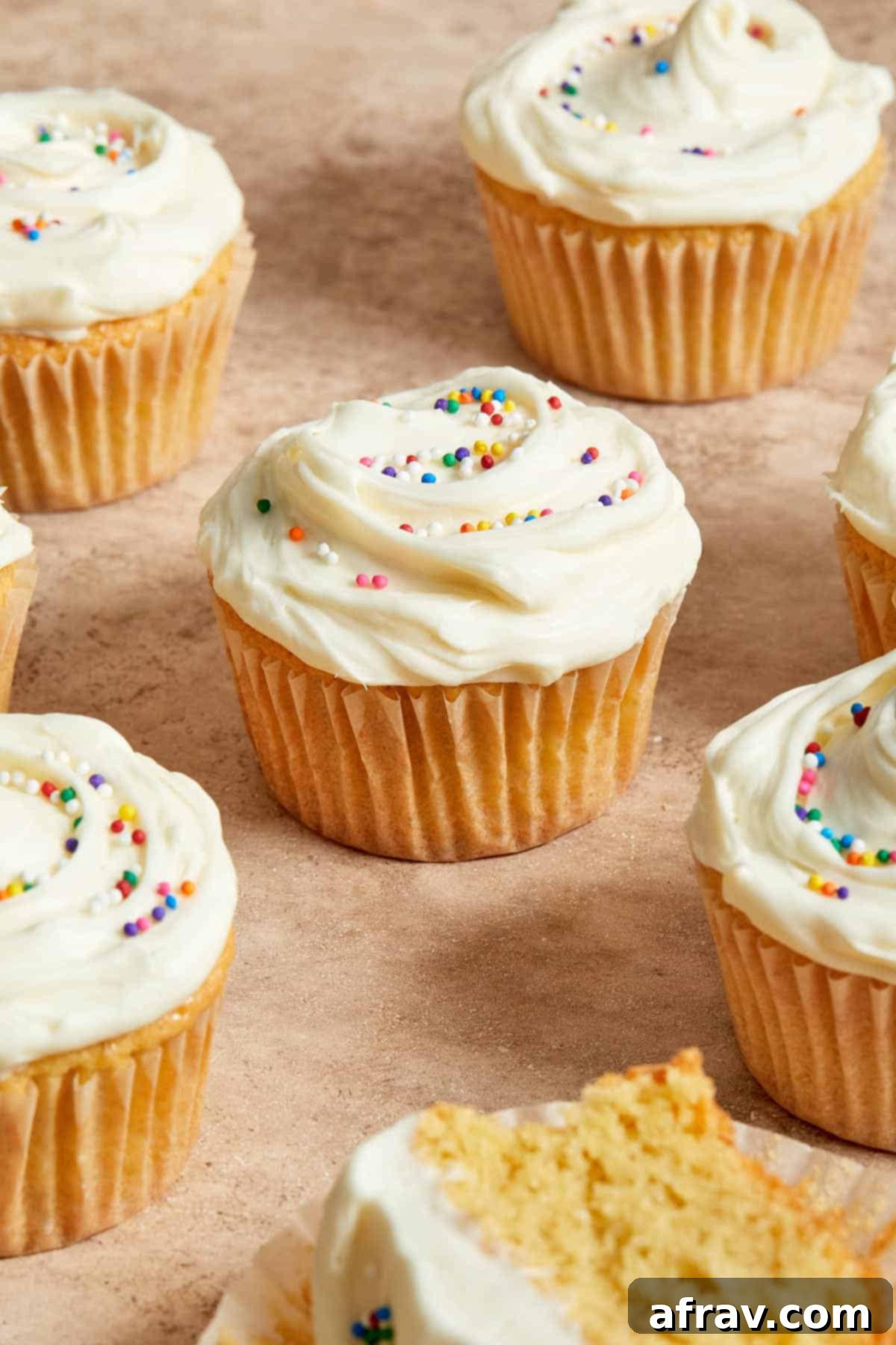 Three-quarter view of almond flour cupcakes arranged on a surface, unfrosted and ready for decoration.