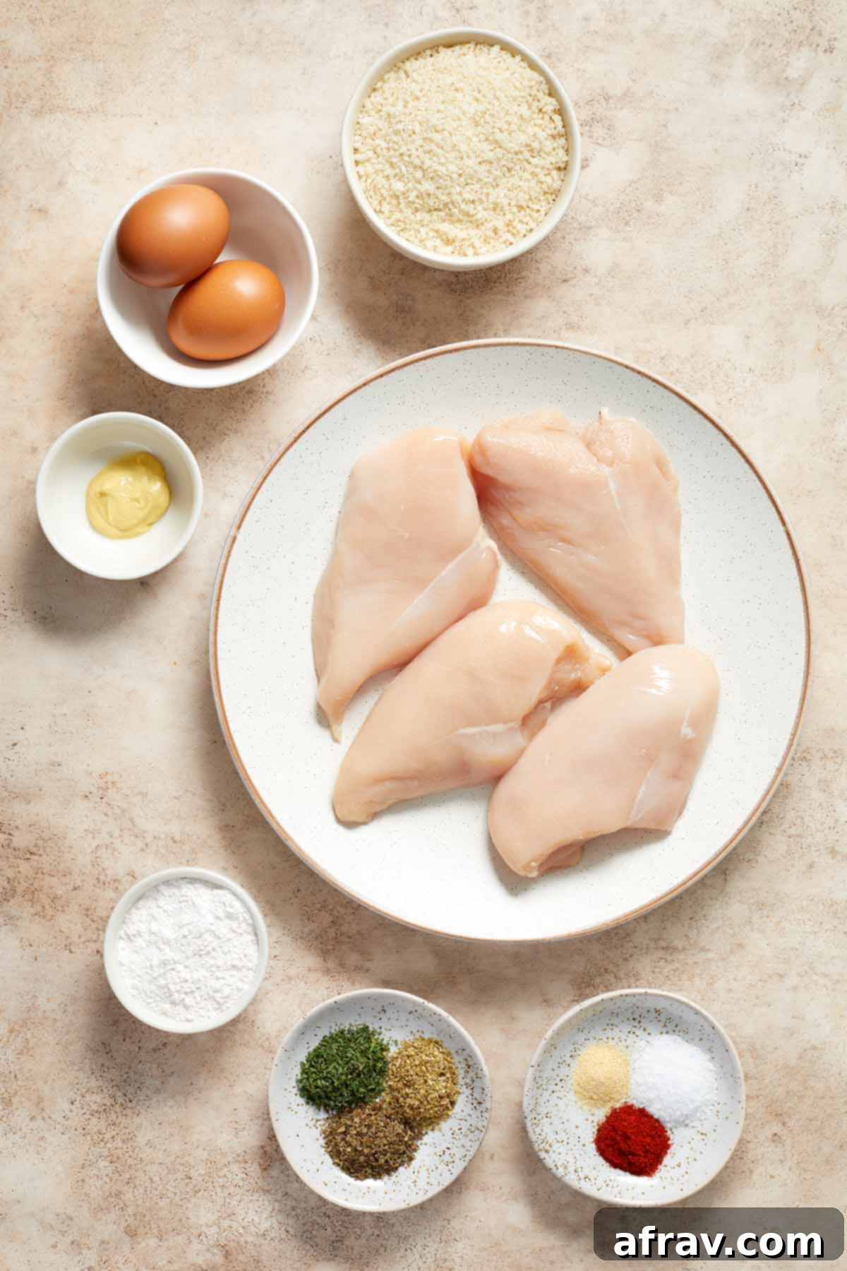 Ingredients for Air Fryer Chicken Schnitzel neatly arranged in separate dishes on a rustic wooden surface.