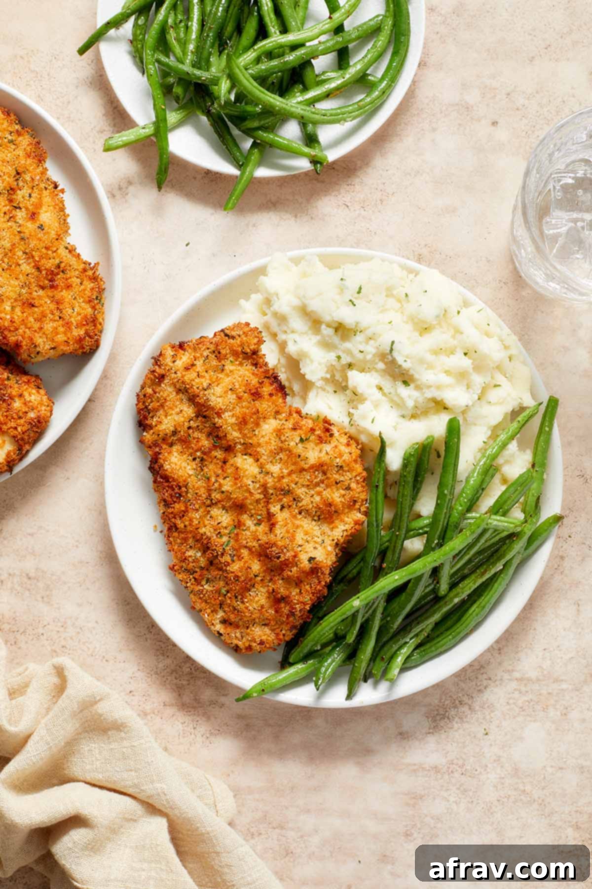Overhead view of a beautifully plated Air Fryer Chicken Schnitzel with steamed green beans and creamy mashed potatoes, ready to be enjoyed.