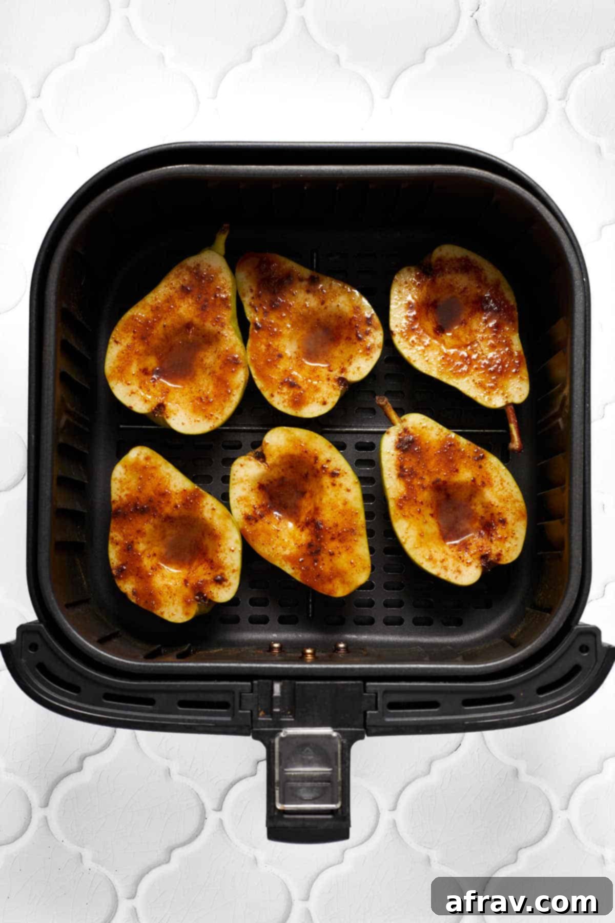 Sweet Air-Fried Pears 4 Six pear halves topped with butter, sugar and cinnamon and arranged in a single layer in an air fryer basket.