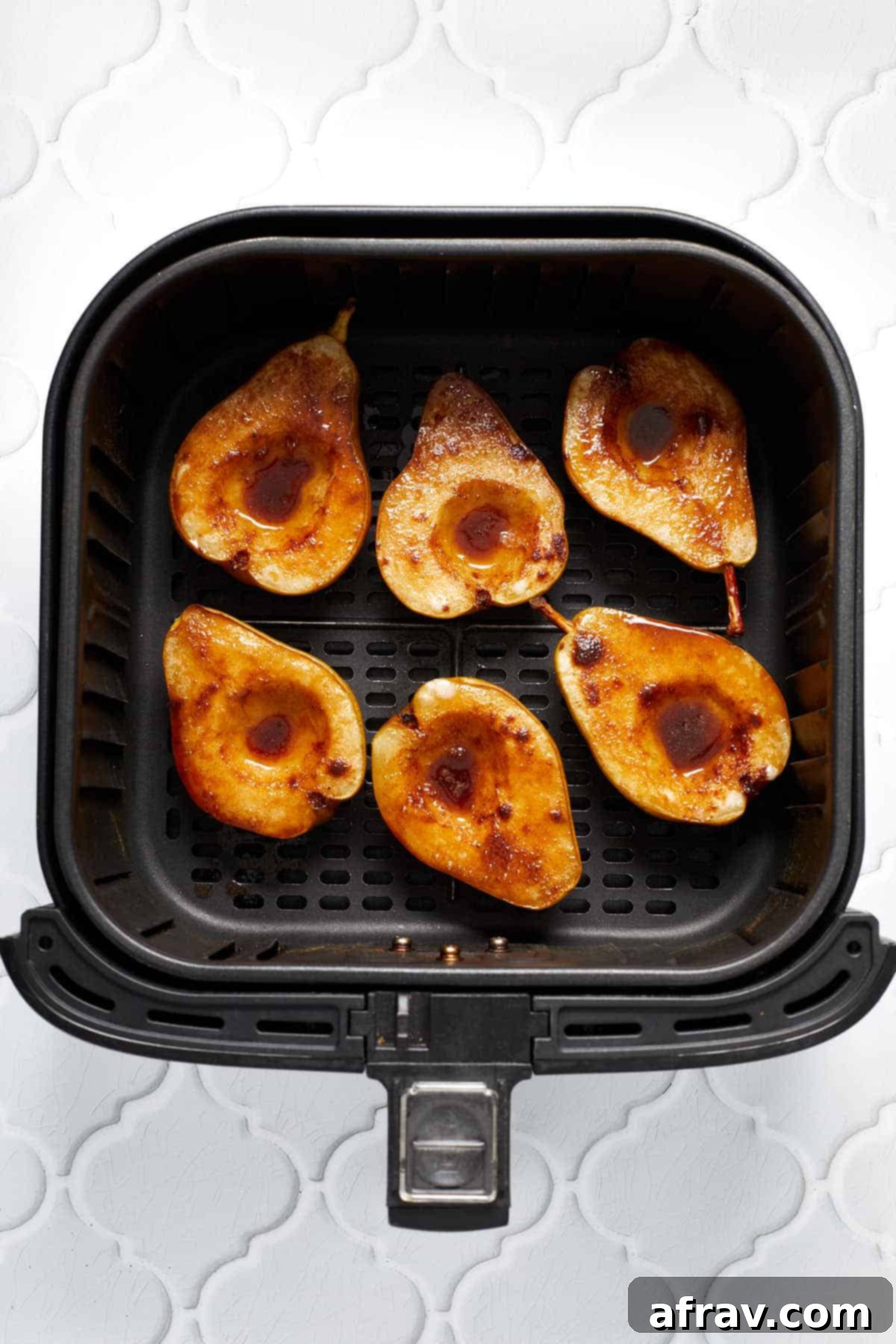 Sweet Air-Fried Pears 5 Baked pear halves in an air fryer basket.