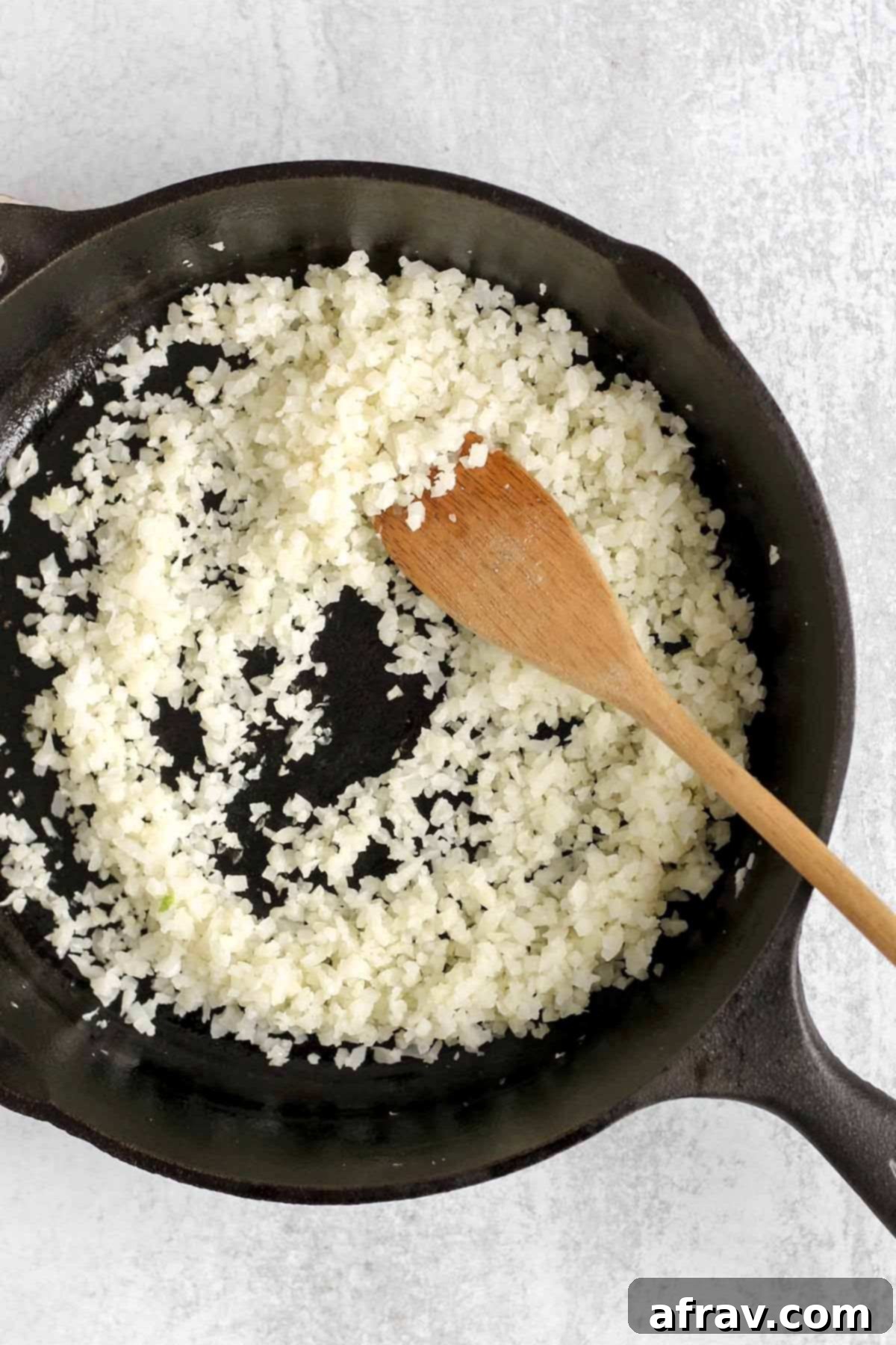 Riced cauliflower in a cast iron skillet.