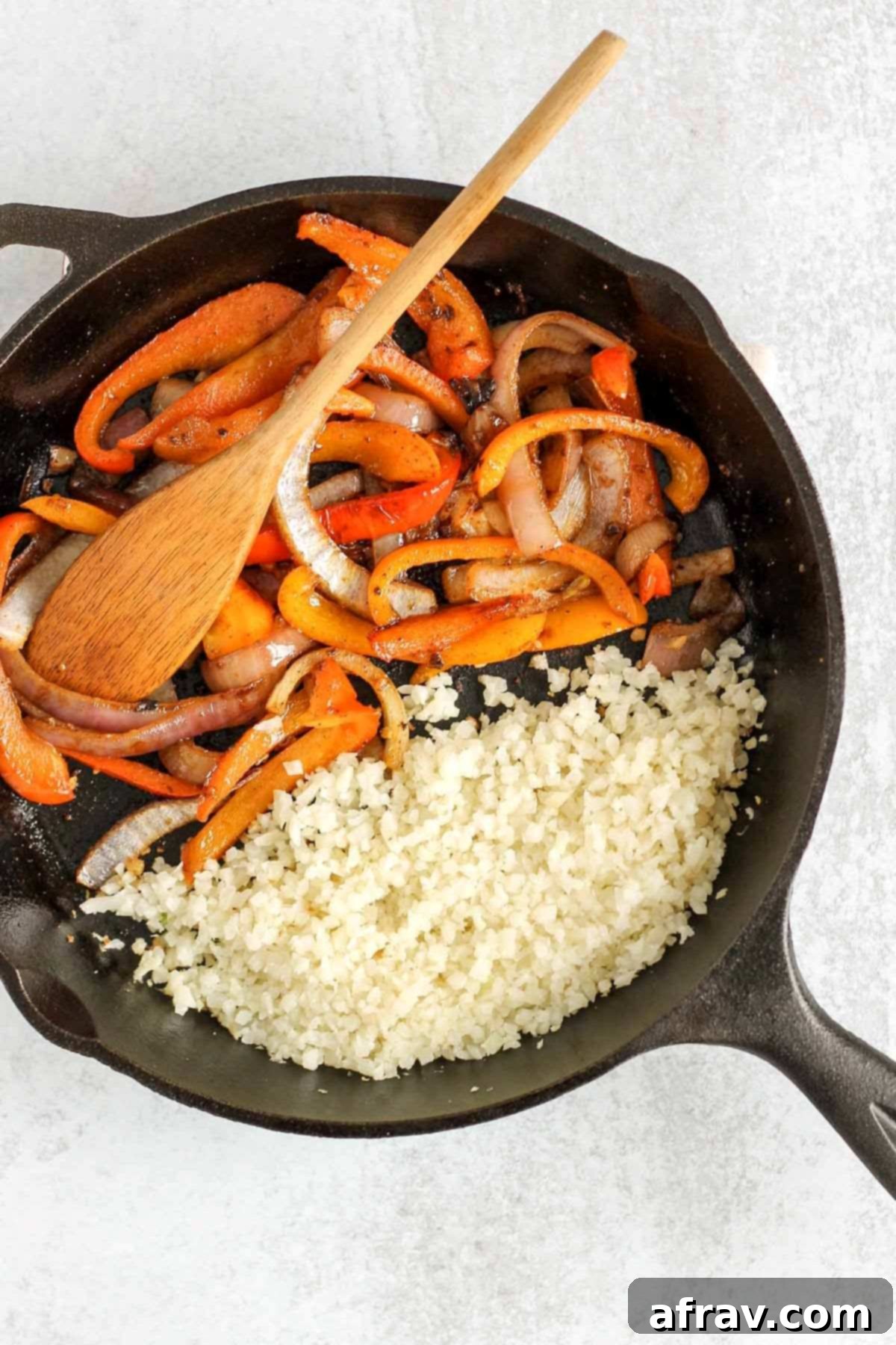 Riced cauliflower and sauteed onions/peppers in a cast iron skillet.