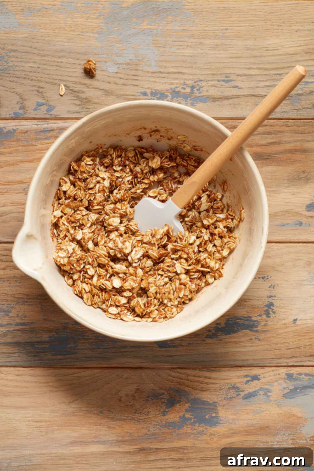 Close-up of the cinnamon oat filling mixture in a glass bowl, with a spatula resting in it, ready for the apples.