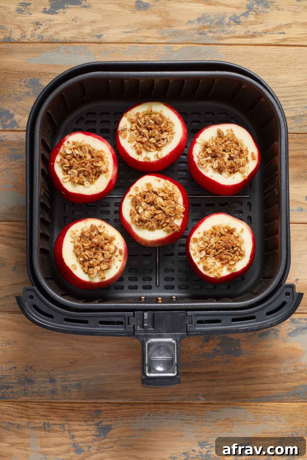 Pre-cooked stuffed apples, ready for the air fryer, arranged neatly in the air fryer basket.