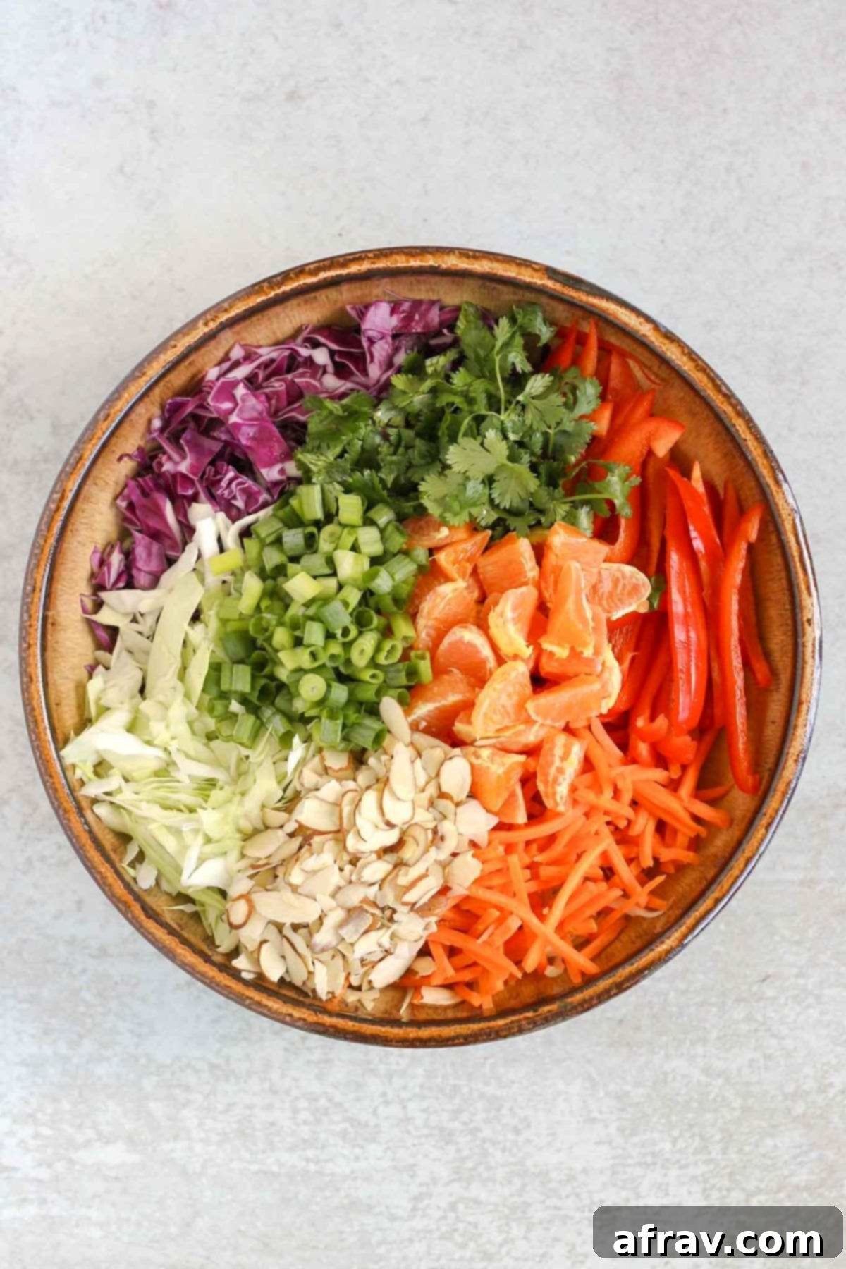 Asian cabbage salad ingredients in a large ceramic bowl.