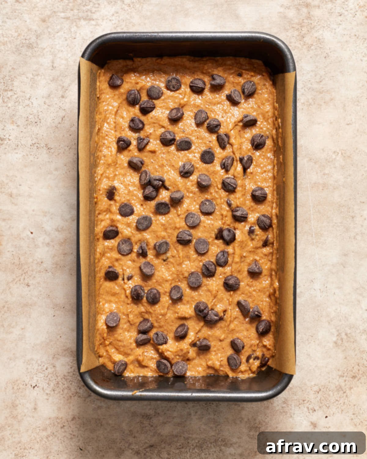 Moist Dairy Free Pumpkin Banana Bread 6 Unbaked pumpkin banana bread batter perfectly poured into a loaf pan, topped with additional chocolate chips, ready for the oven.