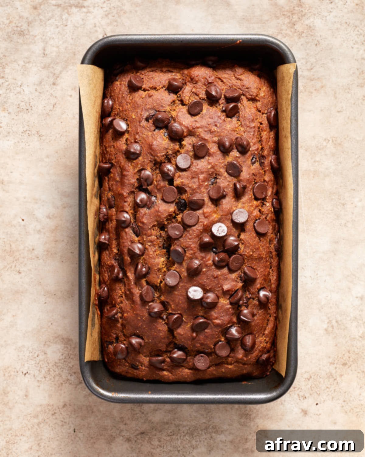 Moist Dairy Free Pumpkin Banana Bread 7 Freshly baked pumpkin banana bread, still warm and golden brown in its loaf pan, showing off its beautiful rise.