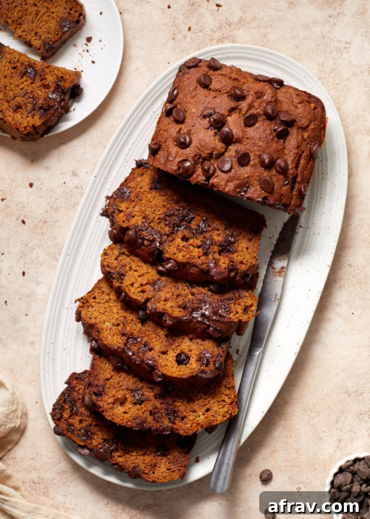 Moist Dairy Free Pumpkin Banana Bread 8 Beautifully sliced banana pumpkin bread arranged on a white platter, ready to be served, showcasing its moist crumb and chocolate chips.