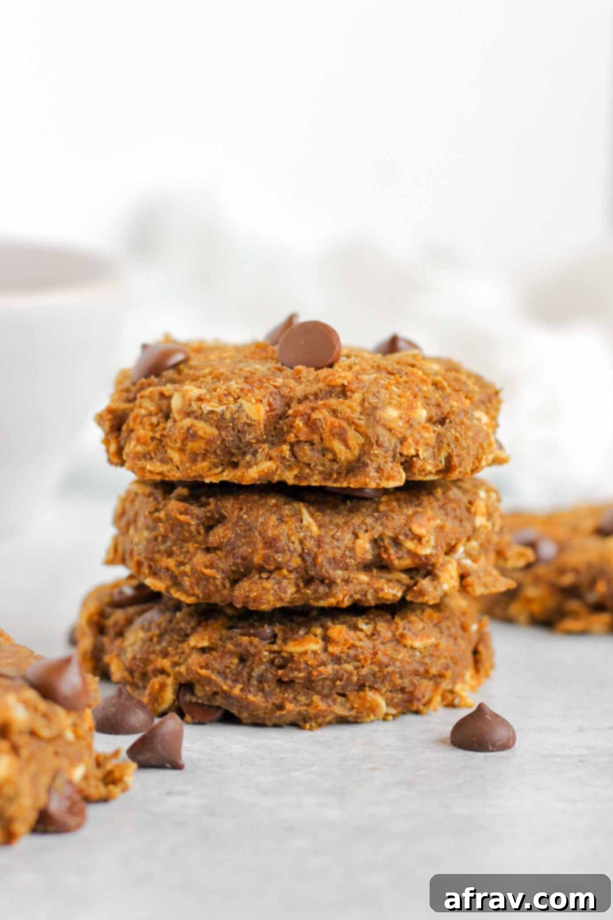 Grab-and-Go Pumpkin Breakfast Cookies 11 Three pumpkin breakfast cookies stacked vertically, showing their soft texture and chocolate chips.
