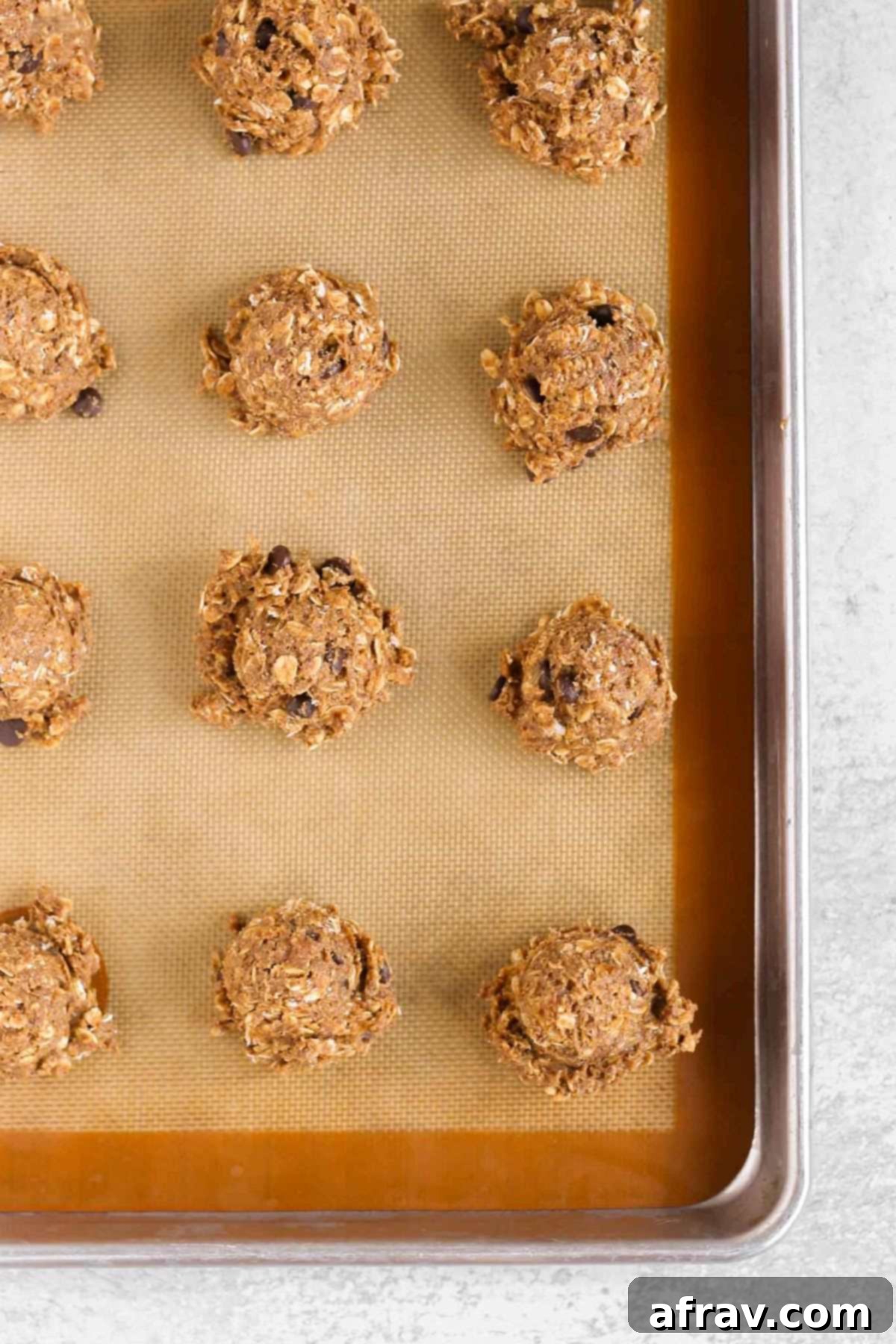 Grab-and-Go Pumpkin Breakfast Cookies 7 Scoops of pumpkin breakfast cookie dough placed on a prepared baking sheet.