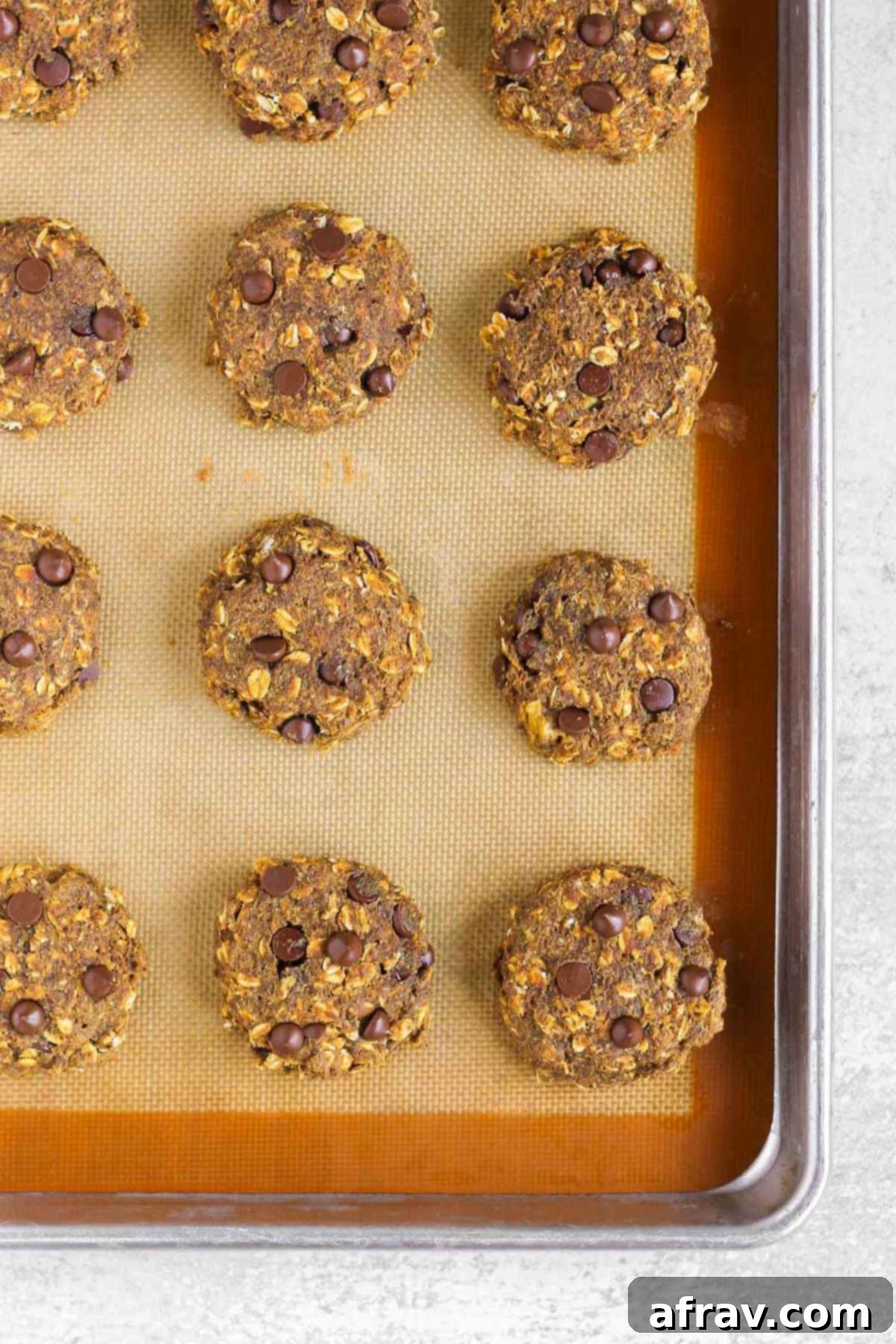 Grab-and-Go Pumpkin Breakfast Cookies 9 Baked pumpkin breakfast cookies on a baking sheet, golden brown and perfectly cooked.