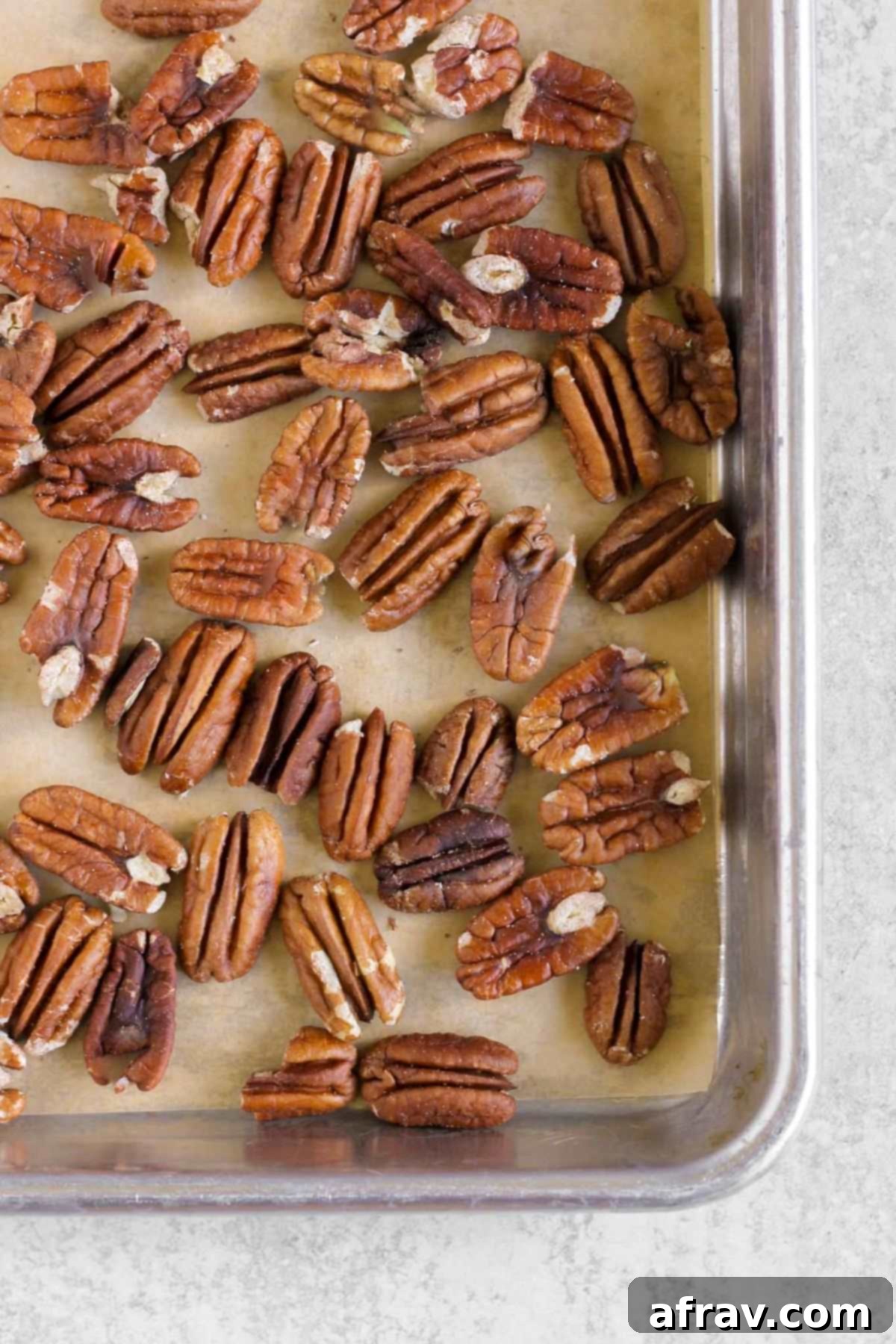 Roasted pecans on a baking sheet.