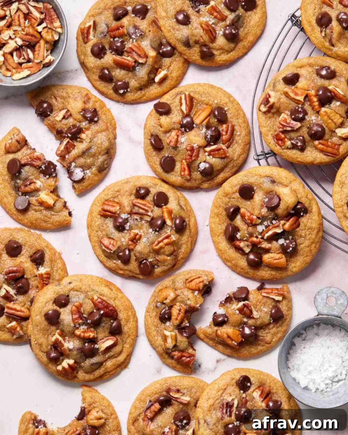 Cookies arranged on a surface with some broken in half, revealing their soft interior and melted chocolate.