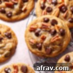 Close up view of a chocolate chip pecan cookie on a wire cooling rack.