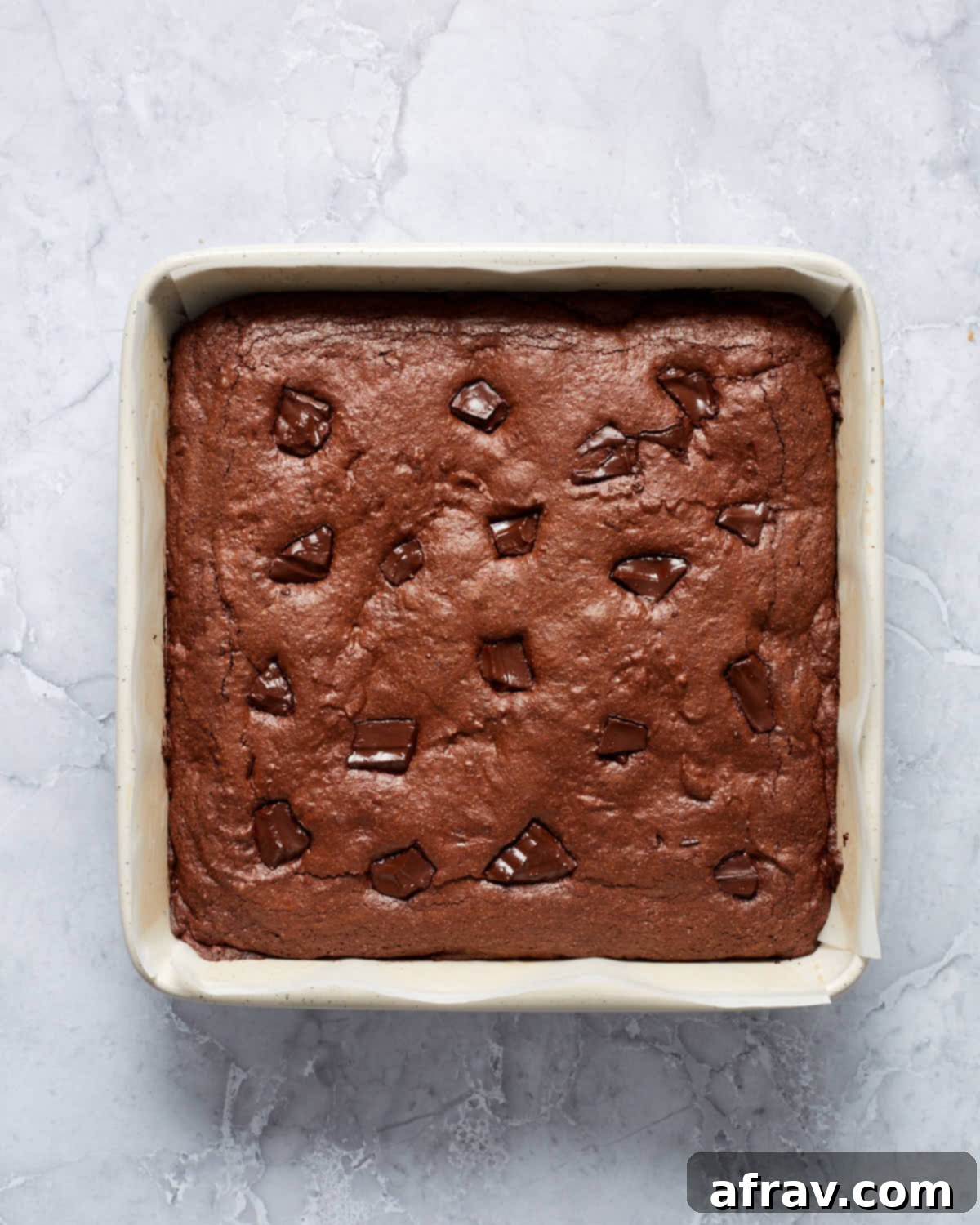Fudgy Oat Flour Brownies 6 Uncut brownies in a square baking pan.