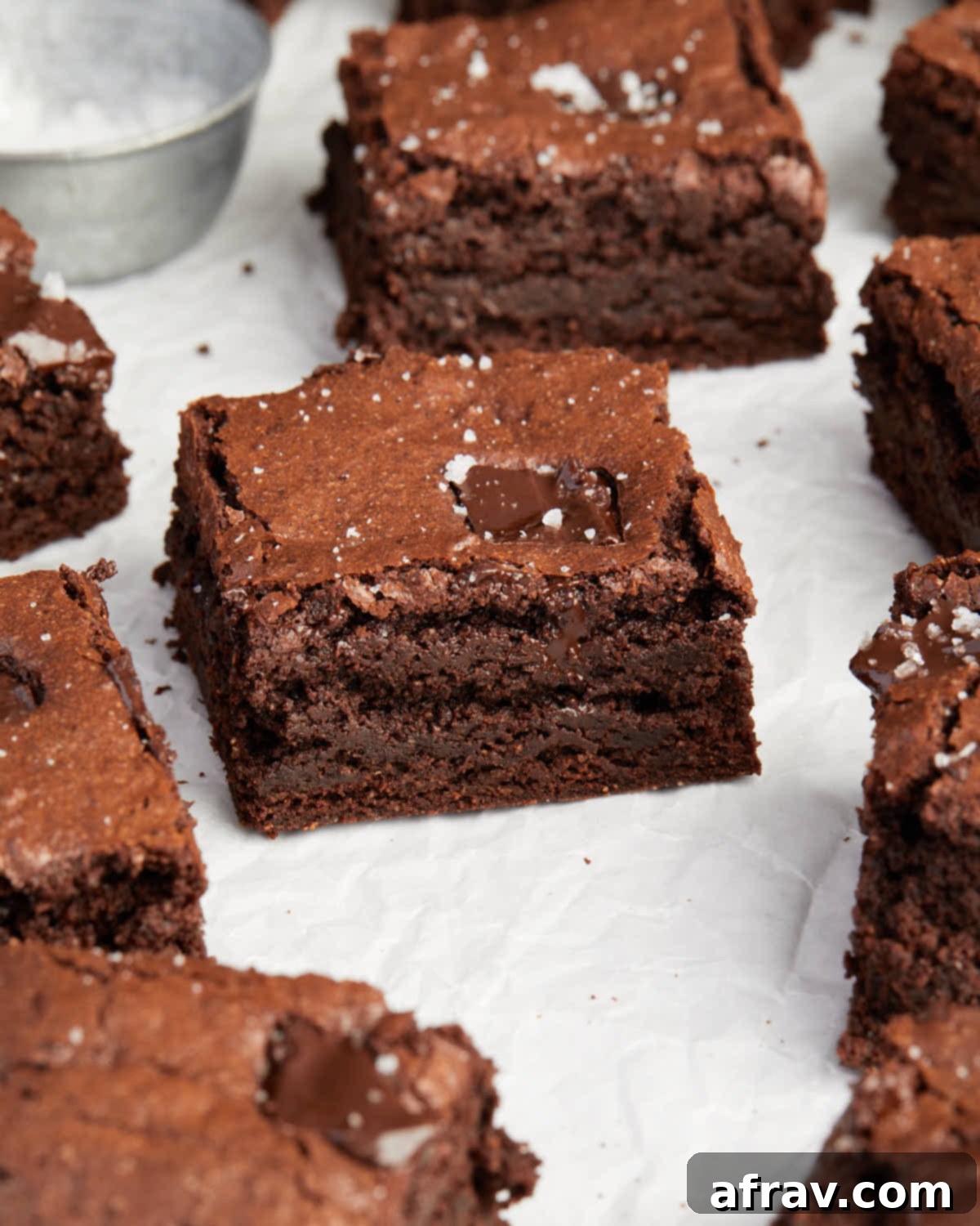 Fudgy Oat Flour Brownies 8 Three-quarter view of brownies arranged on parchment paper.