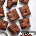 Fudgy Oat Flour Brownies 9 Brownies cut into squares and arranged on crumpled white parchment paper.