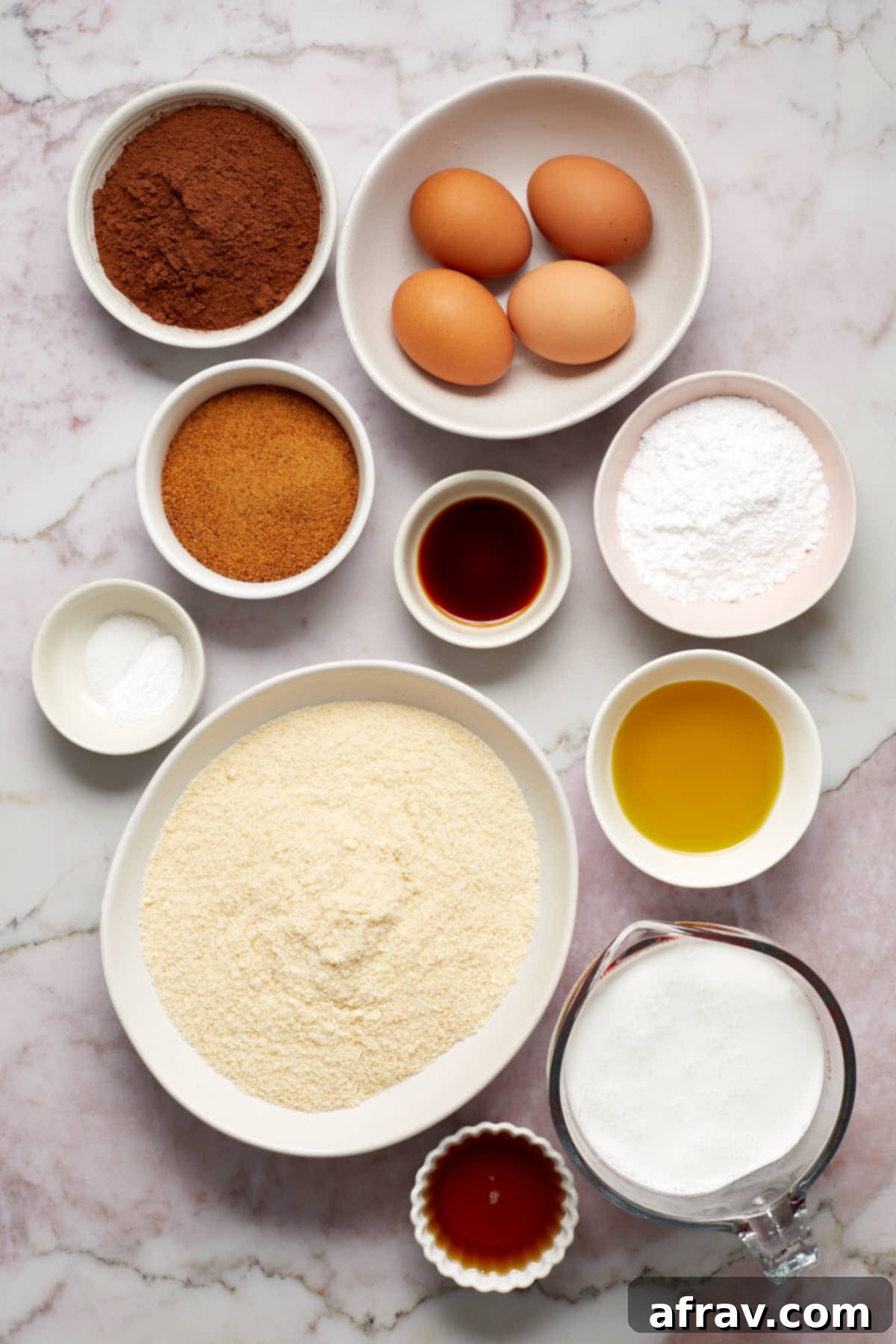 A selection of ingredients for almond flour chocolate cake, neatly arranged in individual bowls.