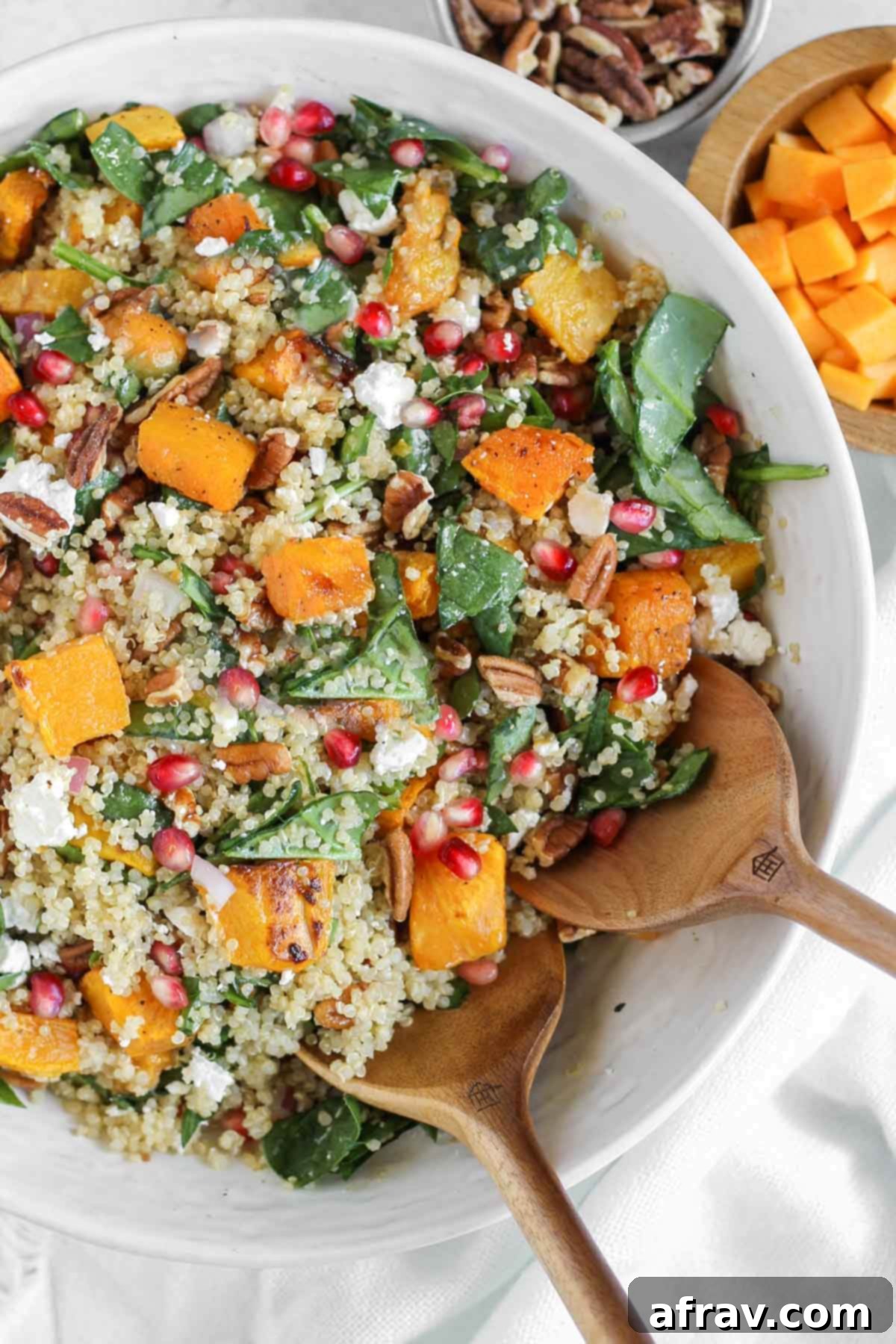 Harvest Quinoa Power Bowl 2 Fall quinoa salad with roasted butternut squash in a large serving bowl with wooden salad utensils.