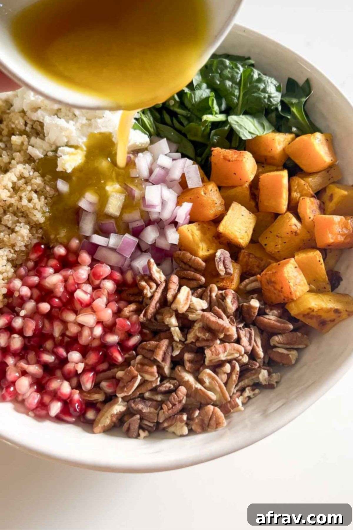 Harvest Quinoa Power Bowl 8 Dressing being poured over ingredients for fall quinoa salad.