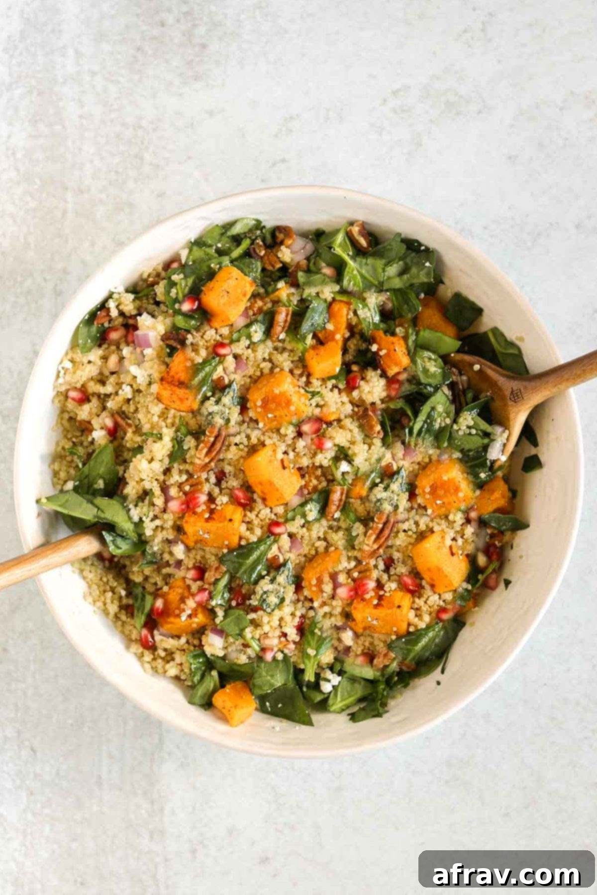 Harvest Quinoa Power Bowl 9 Fall quinoa salad in a large bowl getting mixed with the dressing.