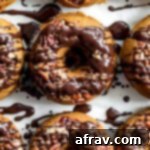 Up-close view of baked pumpkin donuts with chocolate drizzle.