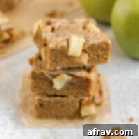 Apple blondies stacked 3 high, showing their soft texture and glaze.