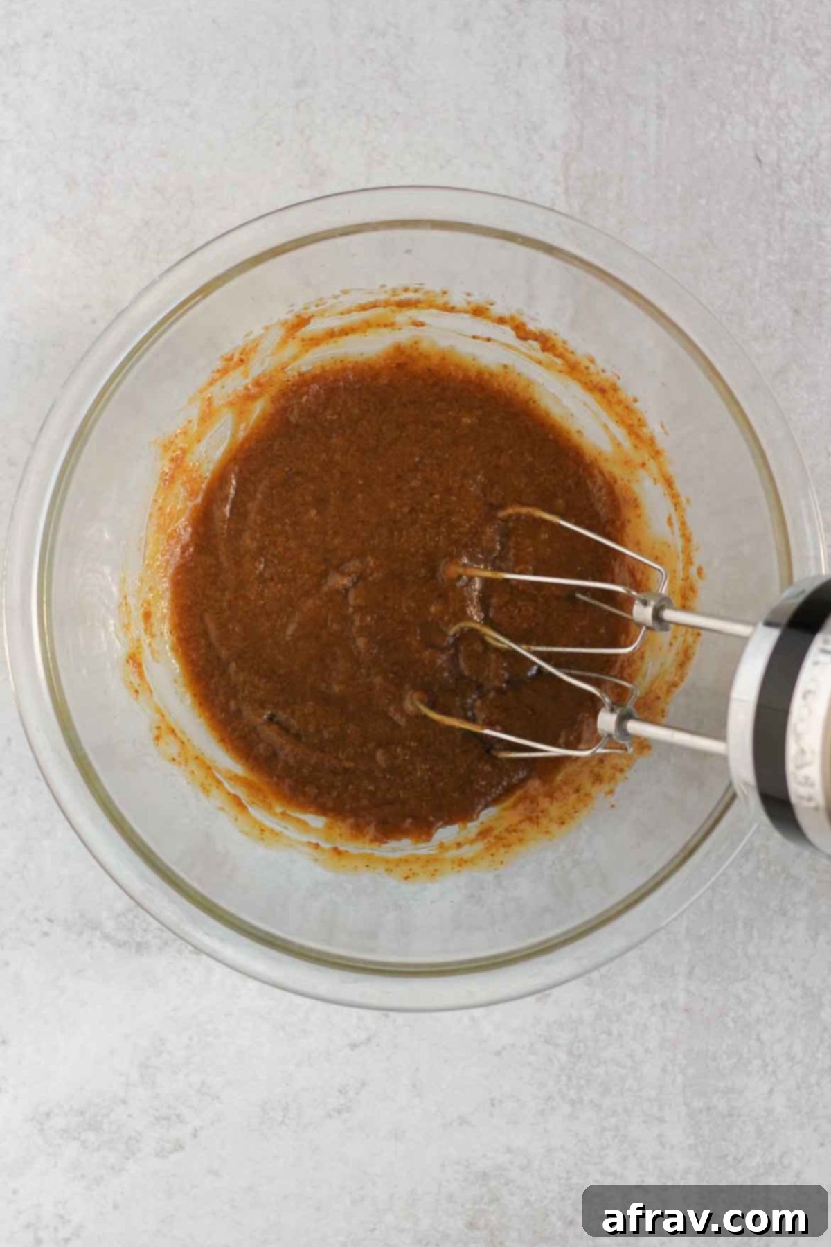 Butter, coconut sugar, eggs, and vanilla mixed together in a glass mixing bowl, creating a smooth wet mixture.