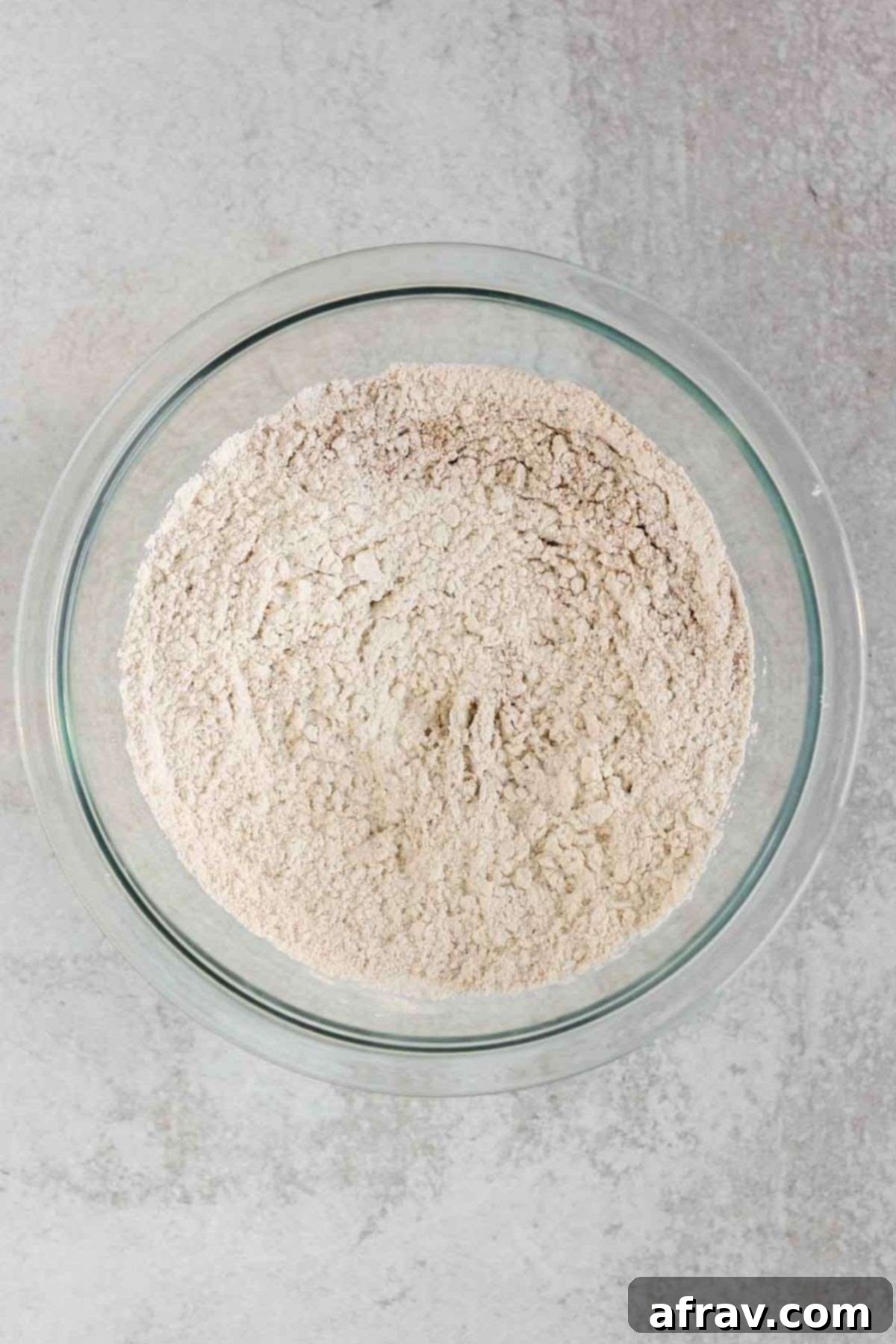 Flour mixture, including gluten-free flour, baking powder, spices, and salt, in a small glass mixing bowl.