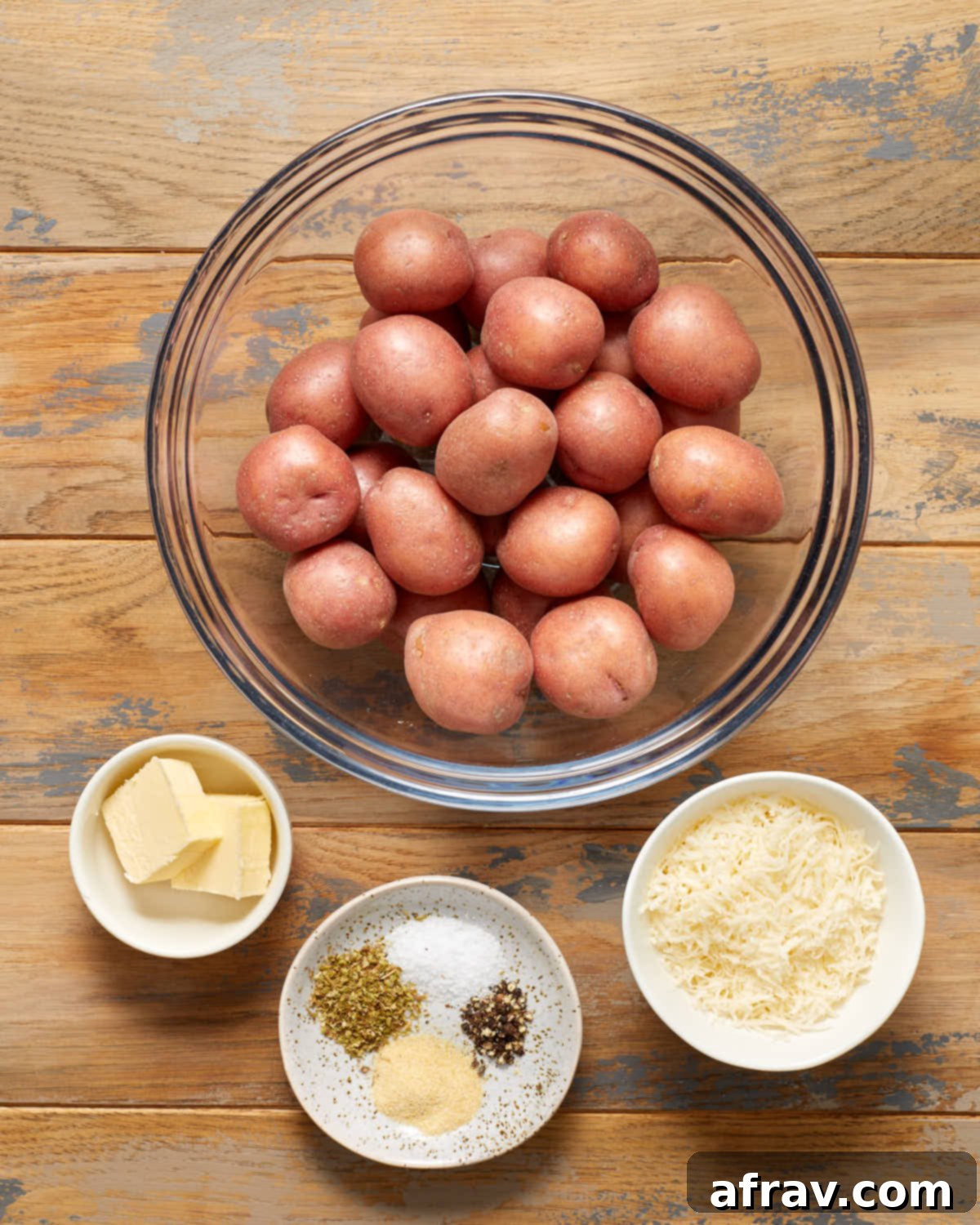 Ingredients to make air fryer parmesan potatoes arranged in individual bowls.