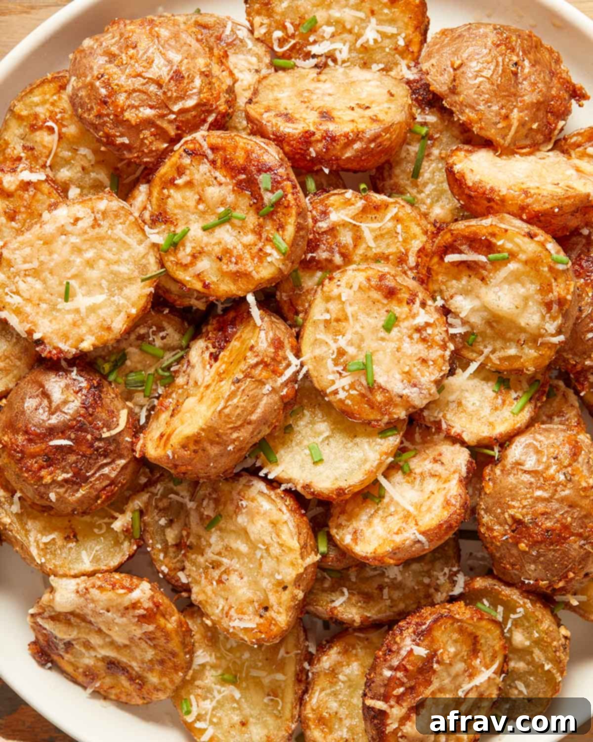 Close up view of air fryer parmesan potatoes on a plate.