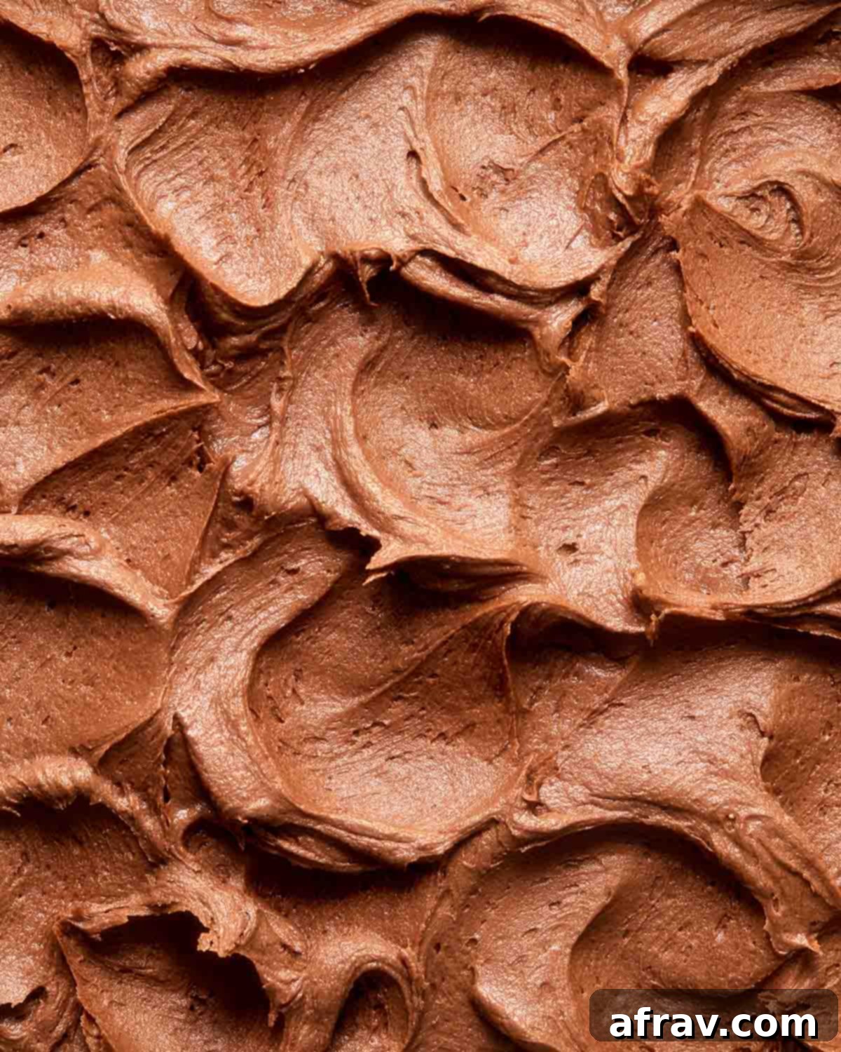 Close-up view of creamy, rich chocolate peanut butter frosting, ready to be spread.
