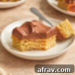 Side view of almond flour banana cake with chocolate peanut butter frosting on a white plate, ready to be served.