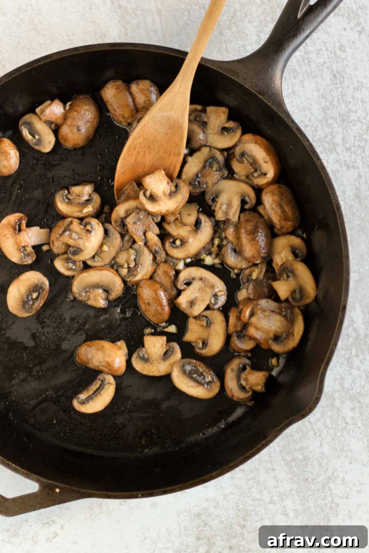 Savory Skillet Green Beans with Onions and Mushrooms 5 Sauteed mushrooms and garlic in a cast iron skillet.