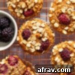 Overhead view of banana blackberry oatmeal muffins on a gold coloured wire rack.